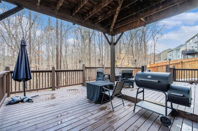 wooden terrace with a grill and fence