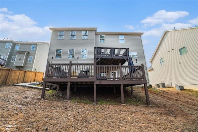 back of property with cooling unit, fence, and a wooden deck