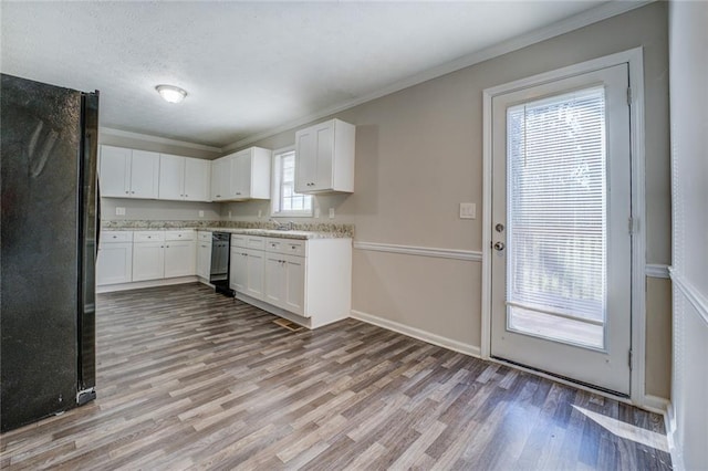 kitchen featuring light wood-type flooring, white cabinets, black appliances, crown molding, and sink