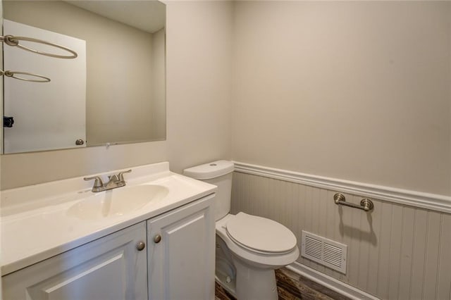 bathroom with hardwood / wood-style floors, toilet, and vanity