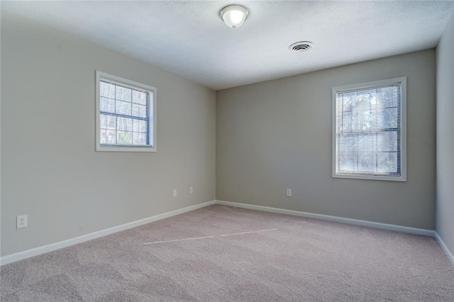 carpeted empty room with a textured ceiling