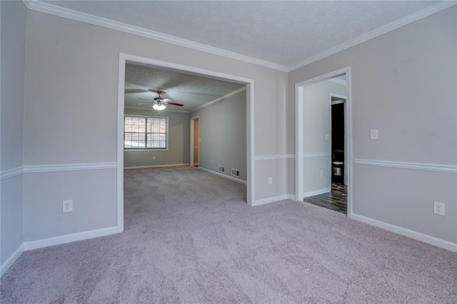 carpeted spare room featuring ceiling fan, ornamental molding, and a textured ceiling