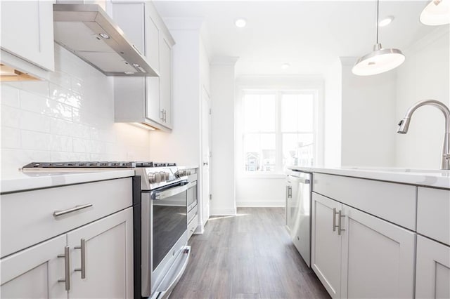5448 Howington Ct E Unit 194, Buford, GA 30518 - kitchen featuring appliances with stainless steel finishes, wall chimney exhaust hood, tasteful backsplash, a sink, and light countertops