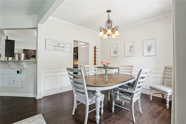 5225 Stonehaven Vw, Cumming, GA 30040 - dining room with a chandelier, crown molding, dark wood-style flooring, a decorative wall, and wainscoting