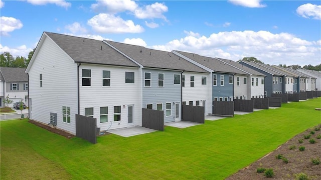 back of property with a yard and a patio area