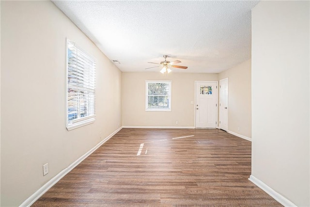 interior space with ceiling fan, wood-type flooring, and a textured ceiling