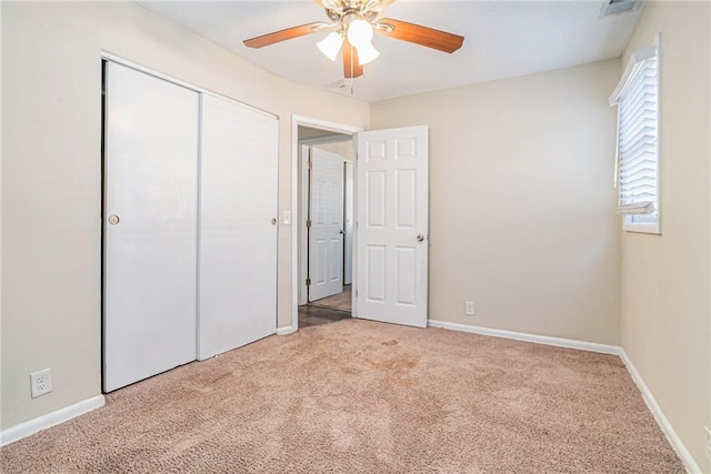 unfurnished bedroom featuring carpet floors, a closet, and ceiling fan