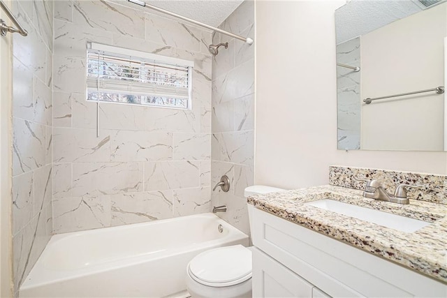 full bathroom featuring a textured ceiling, vanity, tiled shower / bath combo, and toilet