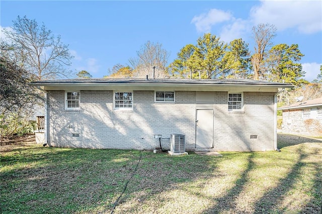 rear view of property featuring a yard and central AC unit