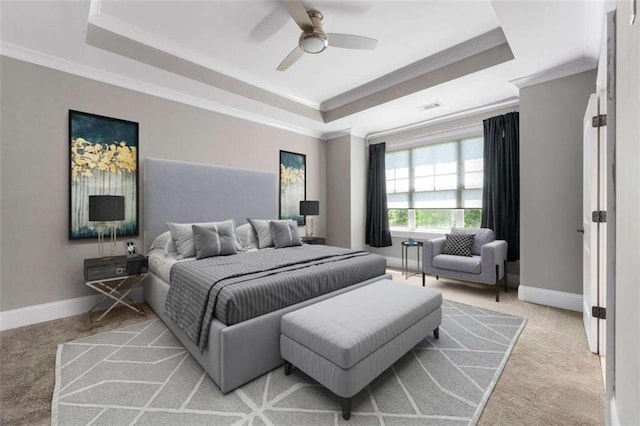 carpeted bedroom featuring a tray ceiling, ceiling fan, and ornamental molding