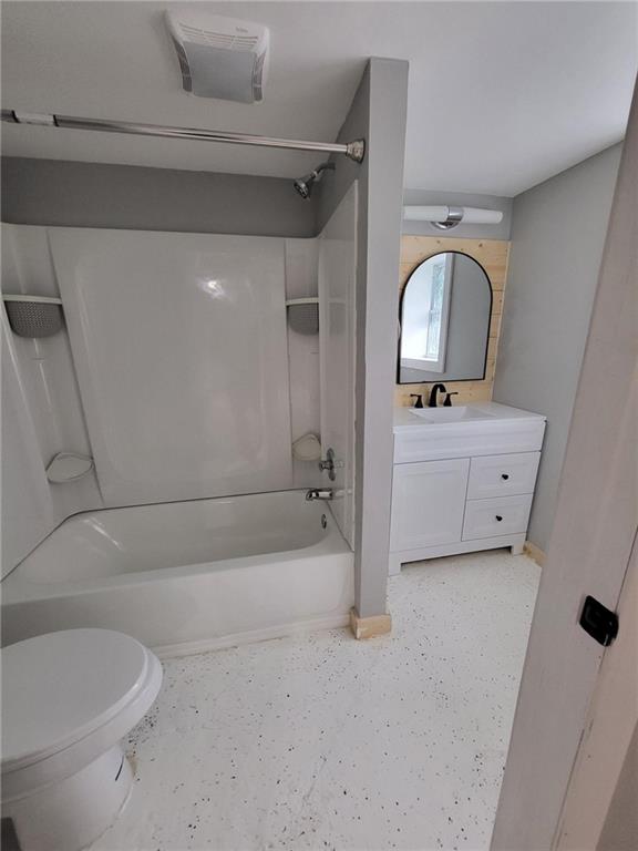 bathroom featuring shower / bathing tub combination, vanity, and toilet