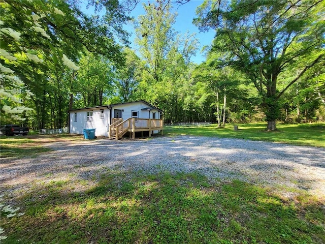 view of front of home with a deck and a front lawn