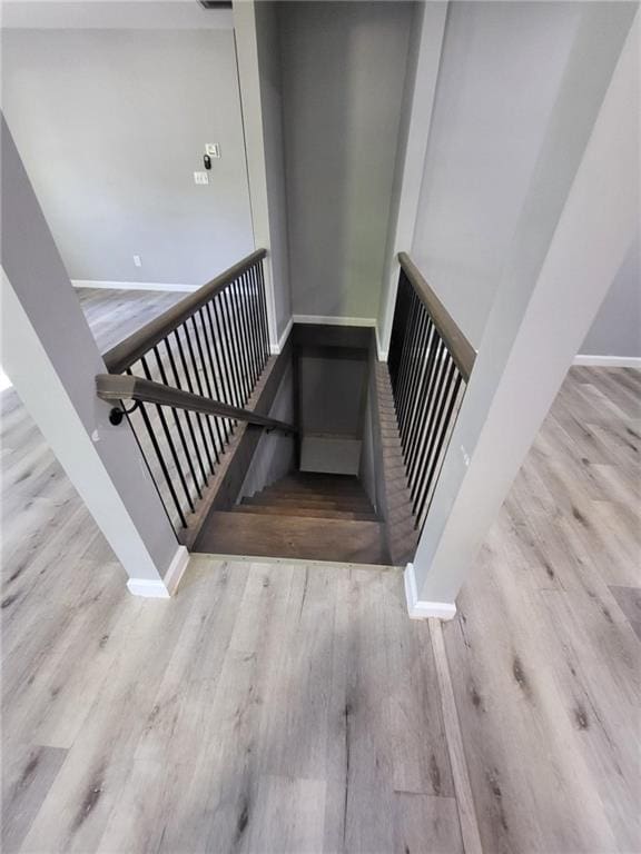 stairway with baseboards, visible vents, and wood finished floors