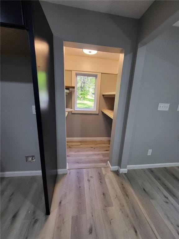hallway with light wood-style floors and baseboards