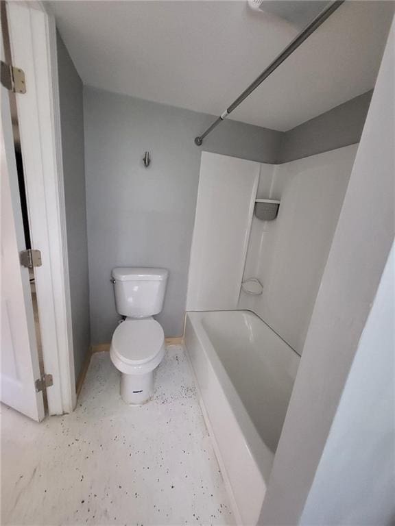 bathroom with toilet,  shower combination, and baseboards