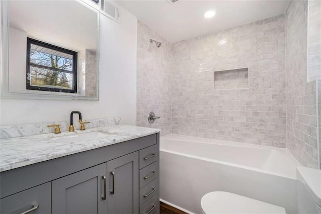 full bathroom with vanity, toilet, and tiled shower / bath combo