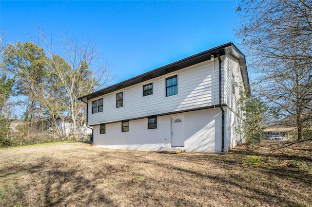 rear view of property featuring a yard