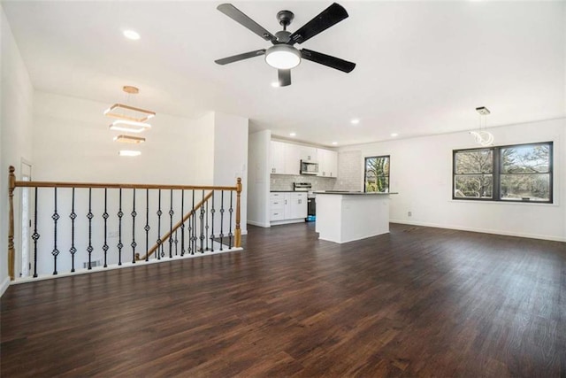 unfurnished living room with dark wood-type flooring and ceiling fan