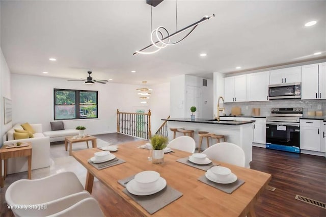 dining room with dark hardwood / wood-style floors, sink, and ceiling fan