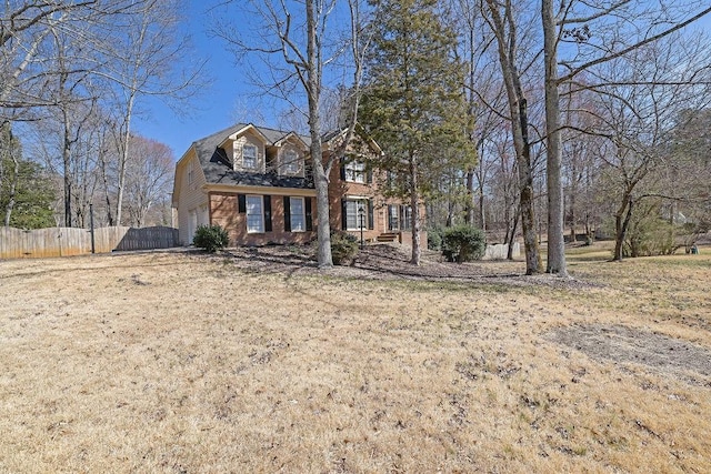 view of front facade with a garage, fence, and brick siding