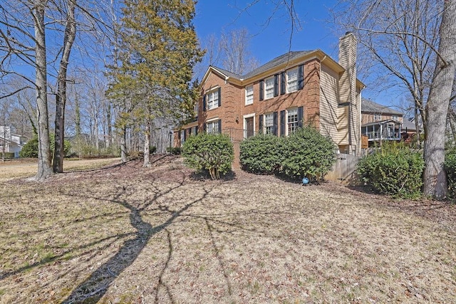 view of property exterior featuring a chimney and brick siding