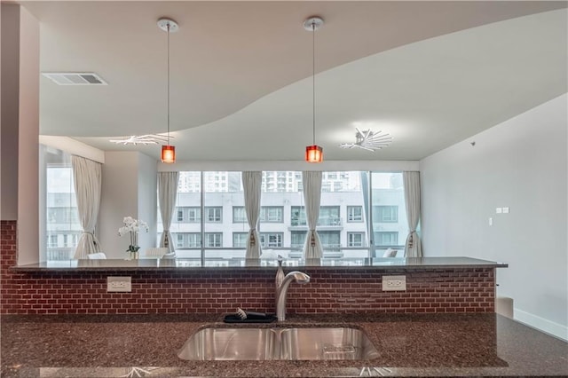 kitchen featuring pendant lighting, sink, backsplash, and a wealth of natural light