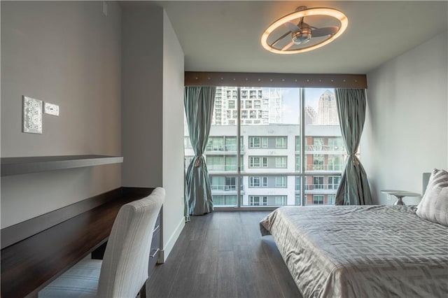 bedroom with floor to ceiling windows and dark hardwood / wood-style floors