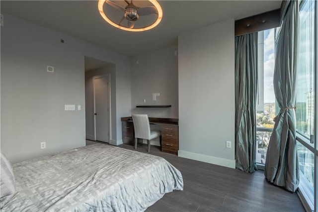 bedroom featuring dark wood-type flooring and expansive windows