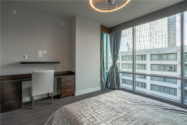 bedroom featuring floor to ceiling windows, dark wood-type flooring, and built in desk