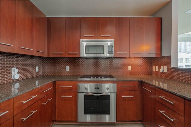 kitchen with tasteful backsplash, appliances with stainless steel finishes, and dark stone countertops