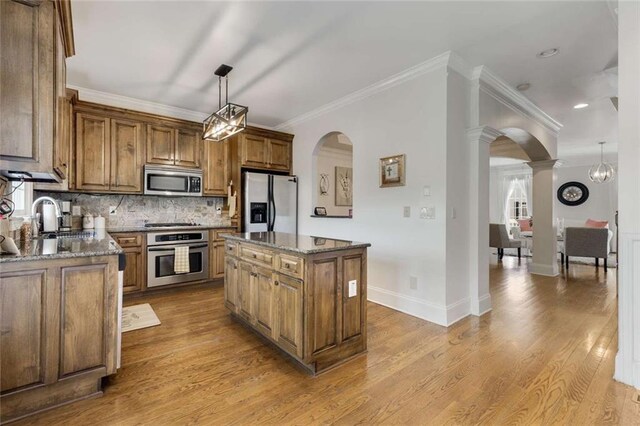 735 Neel Reid Dr, Roswell, GA 30075 - kitchen featuring arched walkways, appliances with stainless steel finishes, crown molding, and a sink