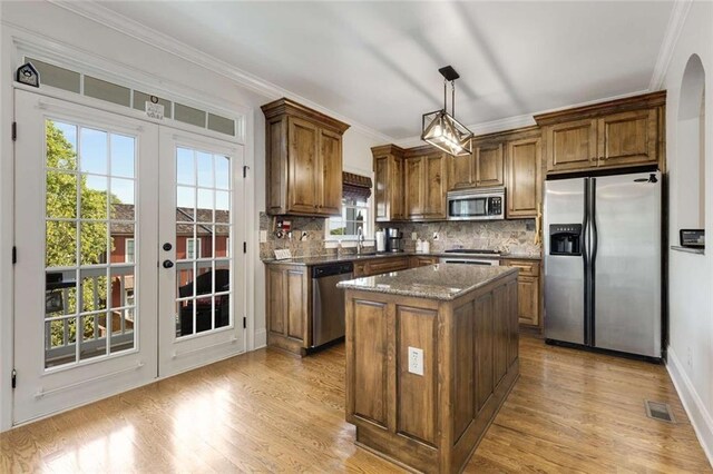 735 Neel Reid Dr, Roswell, GA 30075 - kitchen featuring decorative backsplash, stainless steel appliances, a kitchen island, ornamental molding, and a sink