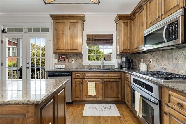 735 Neel Reid Dr, Roswell, GA 30075 - kitchen featuring brown cabinetry, stone counters, appliances with stainless steel finishes, and a sink