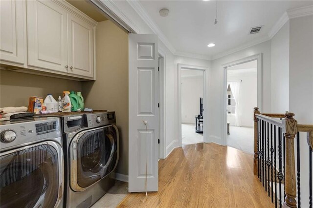 735 Neel Reid Dr, Roswell, GA 30075 - laundry room featuring cabinet space, washing machine and clothes dryer, light wood-style floors, crown molding, and visible vents