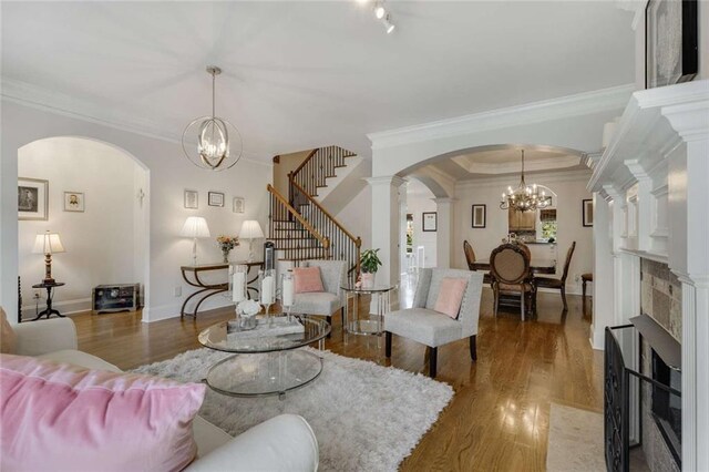 735 Neel Reid Dr, Roswell, GA 30075 - living area with wood finished floors, a chandelier, ornamental molding, and arched walkways