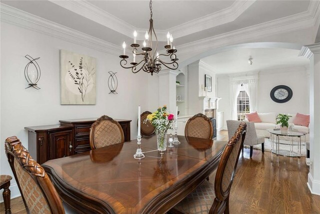 735 Neel Reid Dr, Roswell, GA 30075 - dining area with ornamental molding, dark wood-style floors, arched walkways, and a notable chandelier