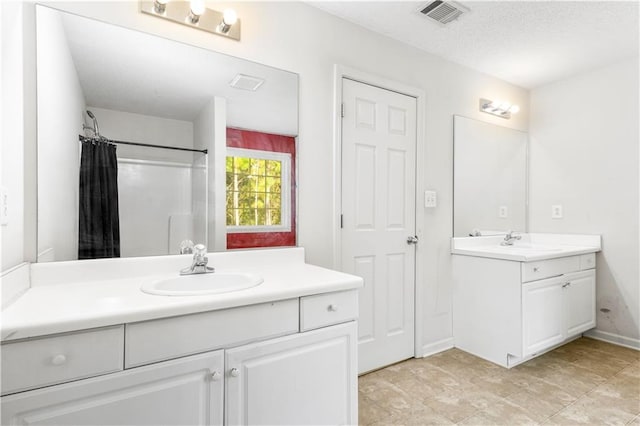 bathroom featuring vanity, a textured ceiling, and a shower with shower curtain