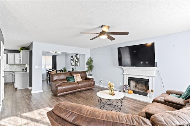 living room with hardwood / wood-style floors, a textured ceiling, and ceiling fan