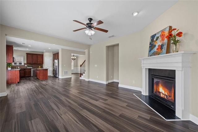 29 Lankford Rd, Tucker, GA 30084 - unfurnished living room with a glass covered fireplace, dark wood-style flooring, stairs, baseboards, and a ceiling fan
