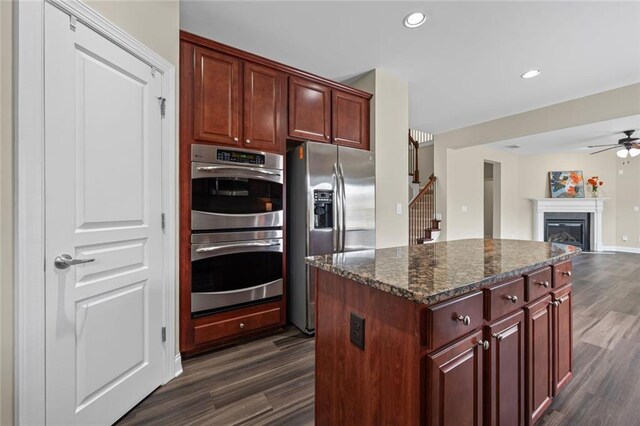 29 Lankford Rd, Tucker, GA 30084 - kitchen with appliances with stainless steel finishes, dark wood finished floors, a ceiling fan, dark stone counters, and a kitchen island