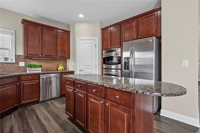 29 Lankford Rd, Tucker, GA 30084 - kitchen featuring stainless steel appliances, dark wood finished floors, tasteful backsplash, dark stone countertops, and baseboards