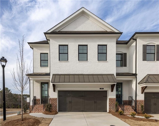 711 Dodd Ln N Unit 166, Buford, GA 30518 - view of front of property with brick siding, a garage, concrete driveway, and a standing seam roof
