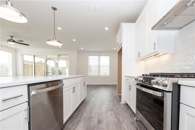 711 Dodd Ln N Unit 166, Buford, GA 30518 - kitchen featuring stainless steel appliances, wall chimney exhaust hood, decorative backsplash, recessed lighting, and light countertops