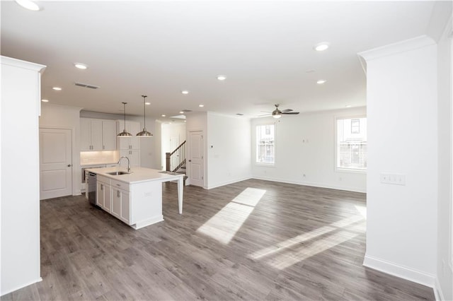 711 Dodd Ln N Unit 166, Buford, GA 30518 - kitchen featuring stainless steel dishwasher, a ceiling fan, baseboards, an island with sink, and wood finished floors