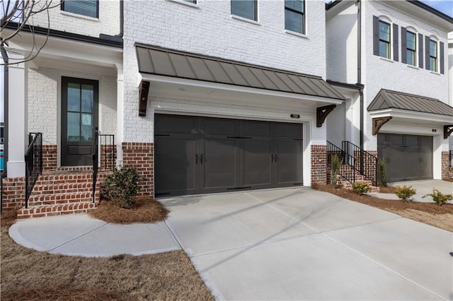 711 Dodd Ln N Unit 166, Buford, GA 30518 - view of front of home with brick siding, a garage, a standing seam roof, driveway, and metal roof