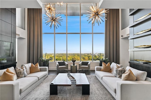 living room with a chandelier, a high ceiling, and a wealth of natural light