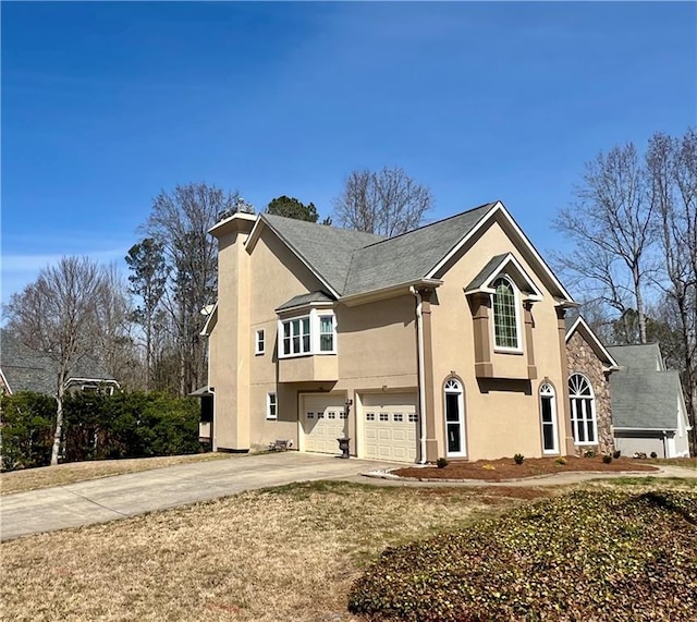 view of front of property featuring stucco siding, an attached garage, and driveway