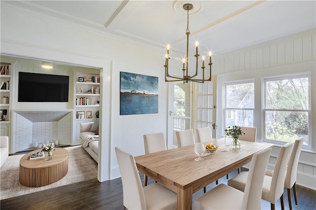 dining area featuring a chandelier, dark hardwood / wood-style floors, built in features, and crown molding