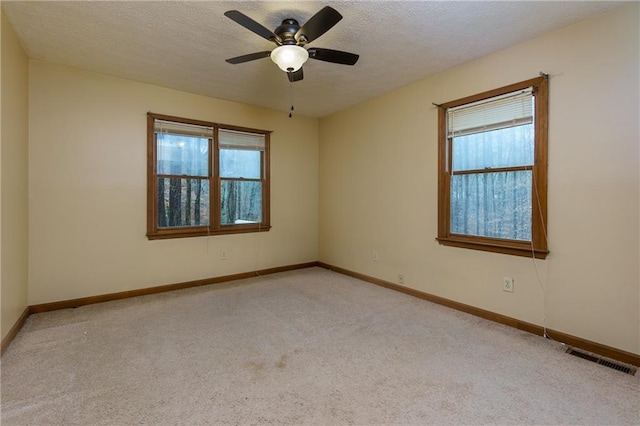 empty room with a textured ceiling, ceiling fan, and light carpet