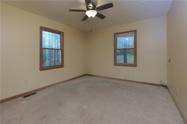 empty room featuring ceiling fan and light carpet